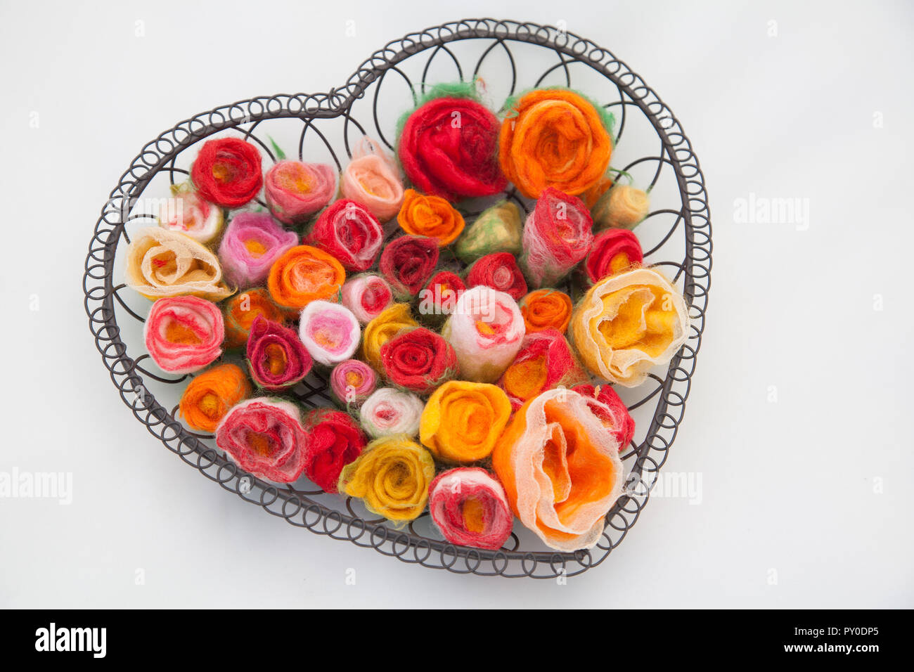 Many felt rose flower blooms in a metal basket for Valentine's Day