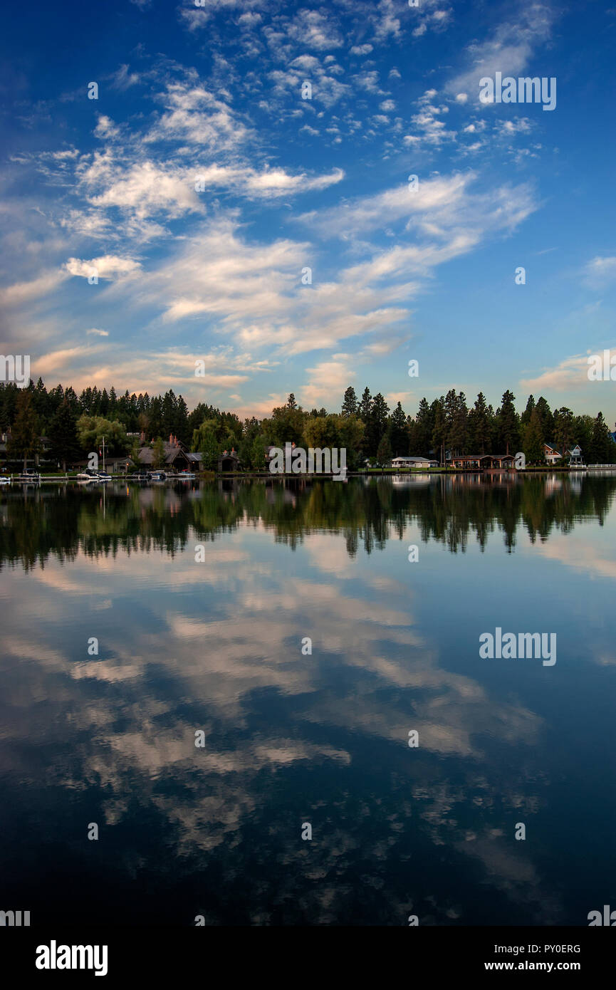 Lodges and trees reflected in clear water of Flathead Lake, Montana, USA Stock Photo