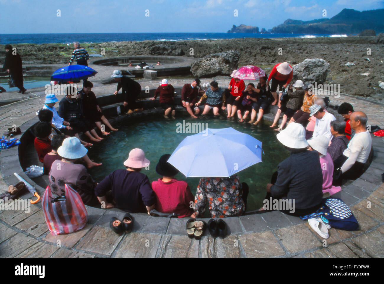 People enjoying saltwater hot springs on sunny day, Lu Tao, Lu Tao Island, Taiwan Stock Photo