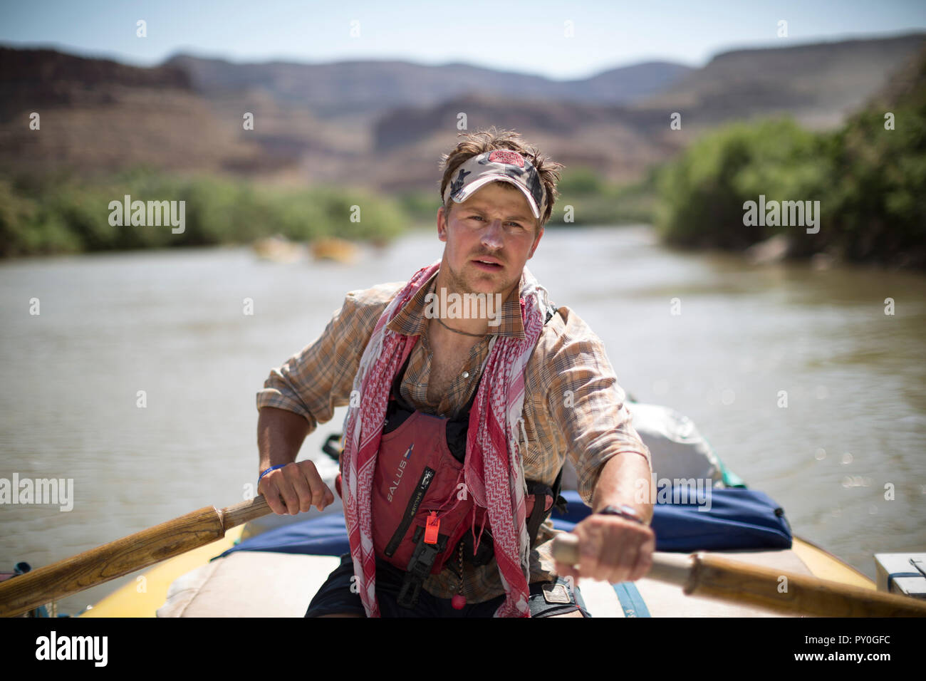 Raft guide man rowing and looking at camera during rafting trip, Desolation/Gray Canyon section, Utah, USA Stock Photo