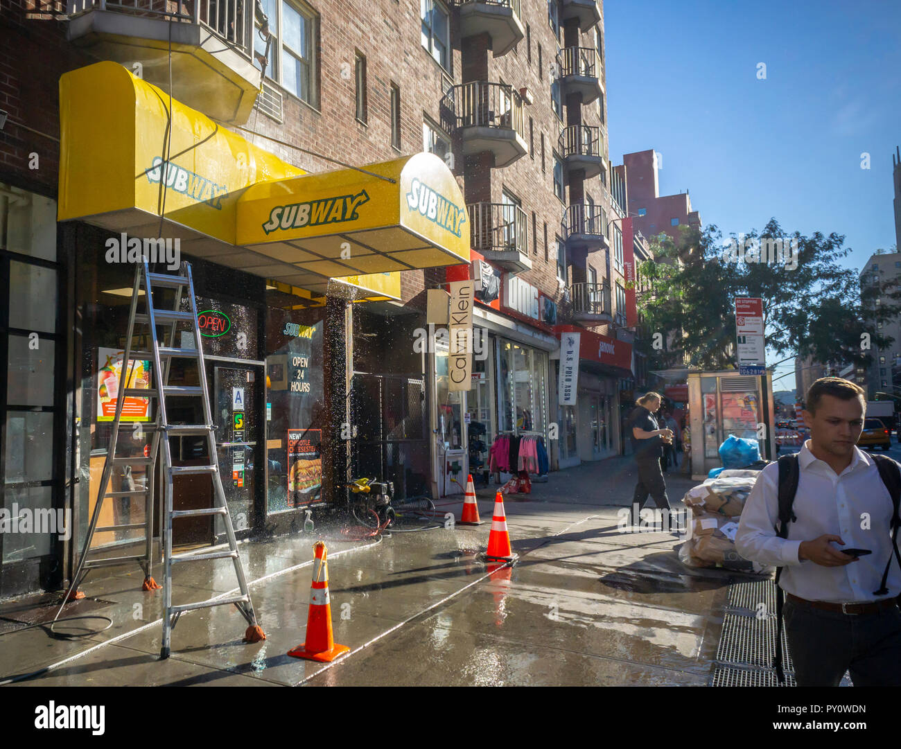 A worker power washes the awning of a franchise of the Subway sandwich chain in the Chelsea neighborhood of New York on Thursday, October 18, 2018. (Â© Richard B. Levine) Stock Photo