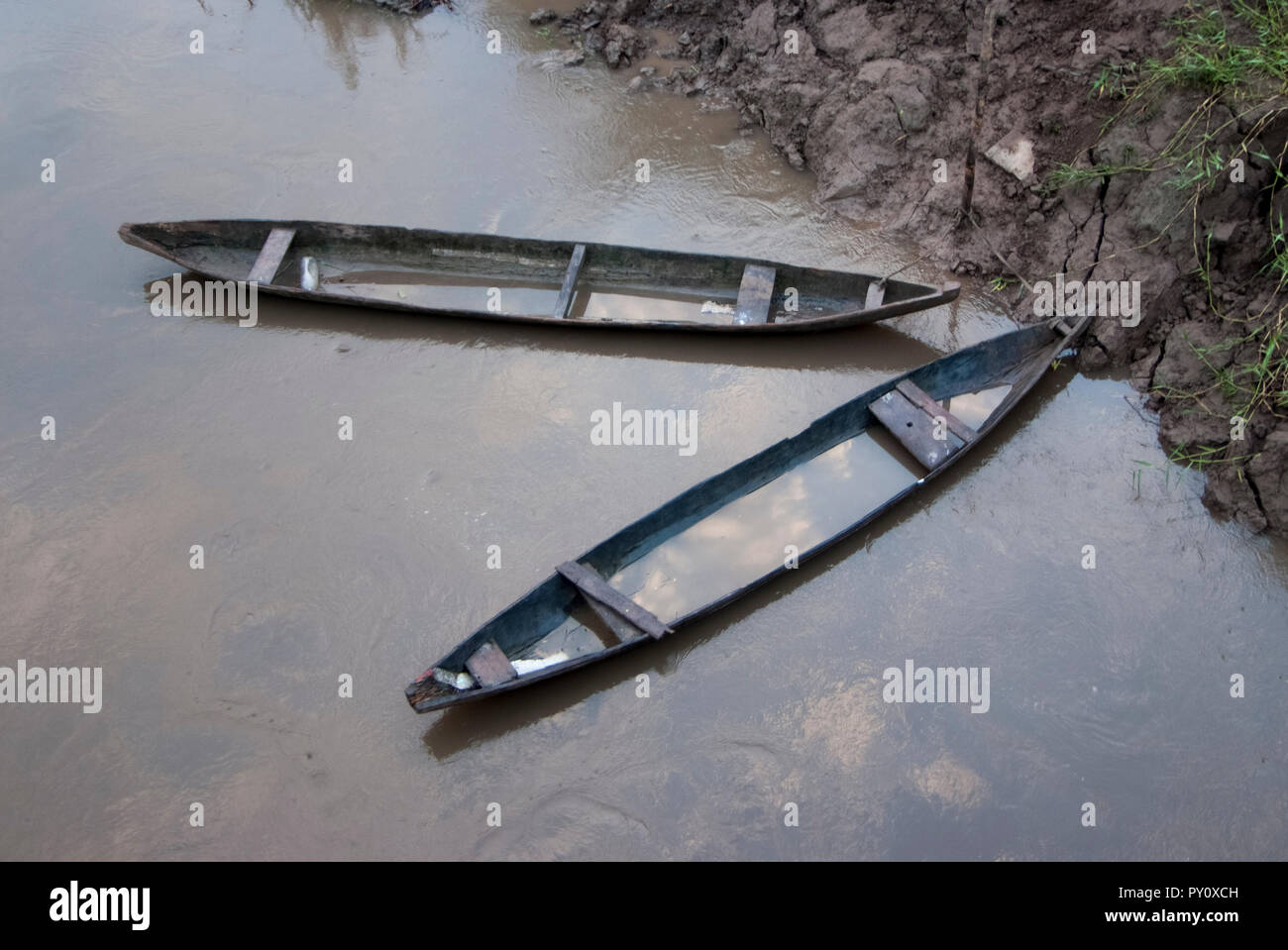 Two traditional wooden canoes at sunset in the Amazon River basin with