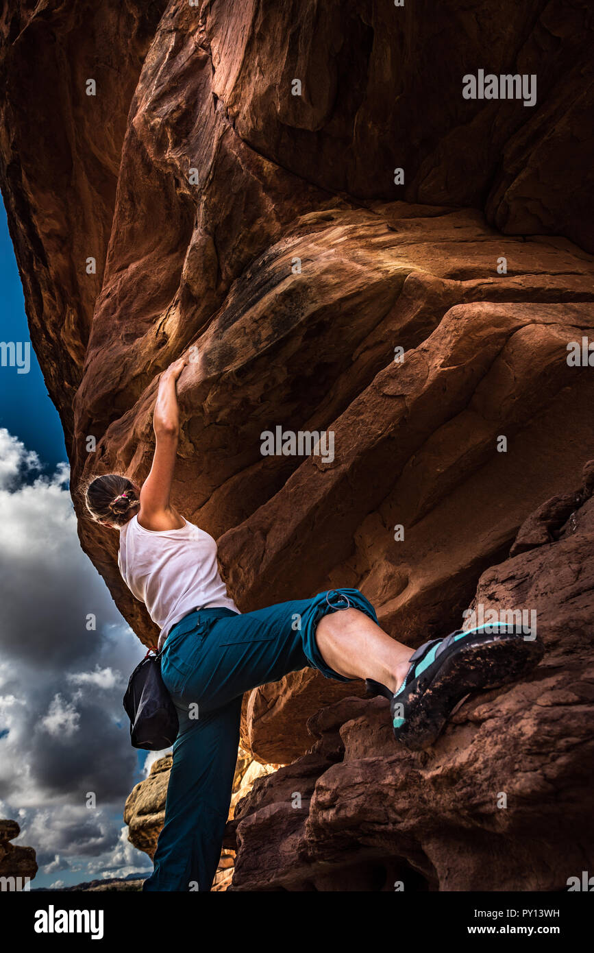 Women Climber practicing bouldering on a beautiful red rock in Canyonlands Utah USA Stock Photo