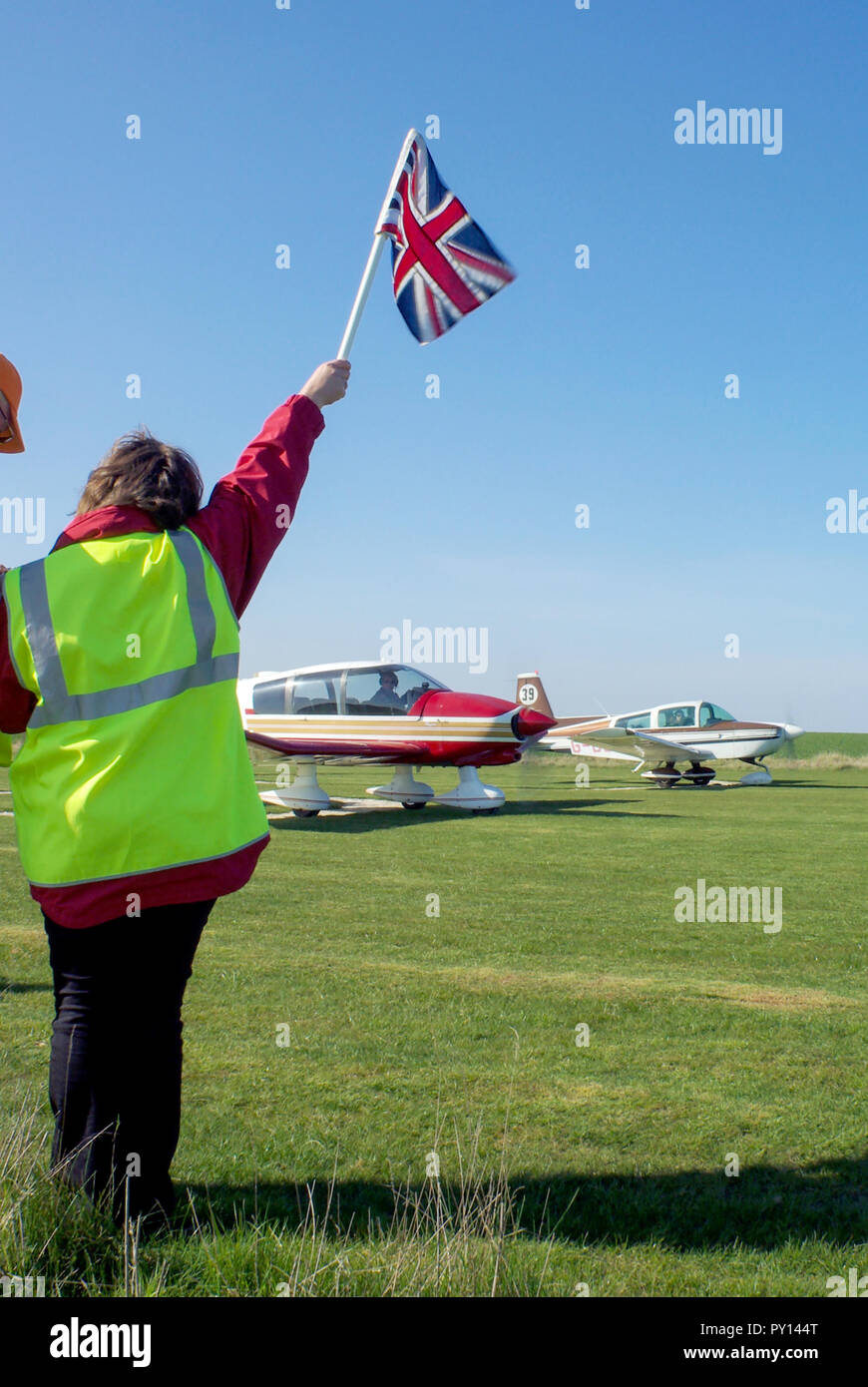 Start of the Royal Aero Club RAeC Air Race Series at Great Oakley airfield, Essex, UK. Private flying. Raised flag ready to drop. British Union Flag Stock Photo