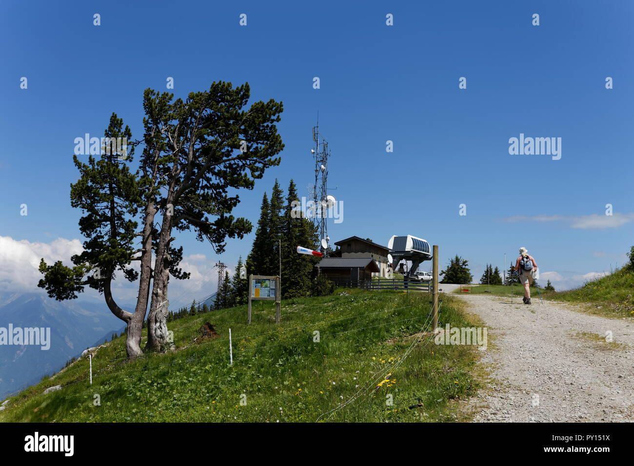 Top chairlift station and a female walker on top of the La Sambuy mountain area near Faverges France Stock Photo