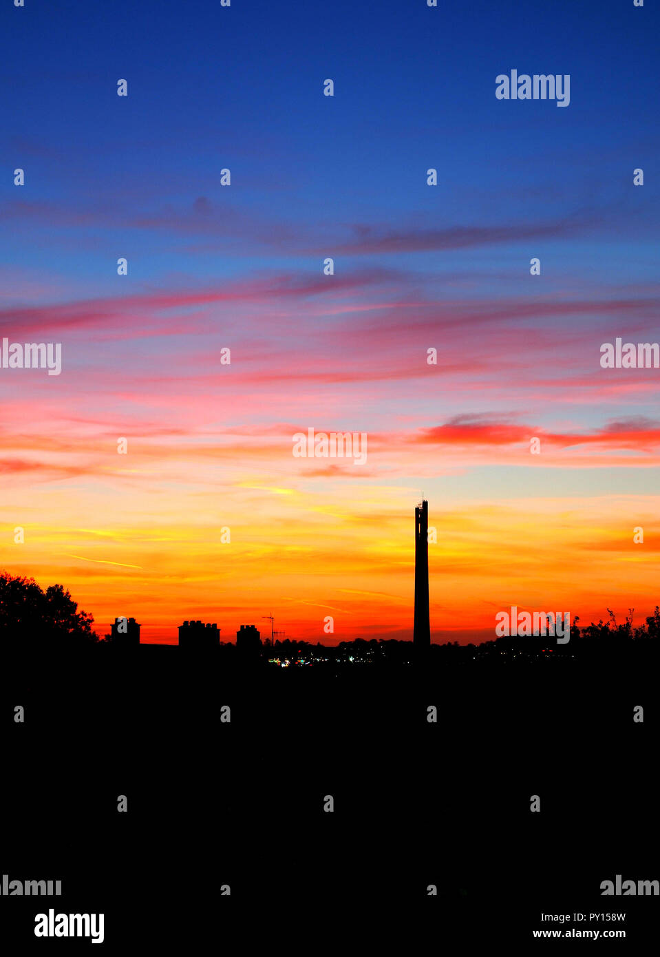 View of the Northampton skyline showing the National Lift Tower (Express Lift Tower), silhouetted against a colourful autumn sunset Northampton, UK Stock Photo