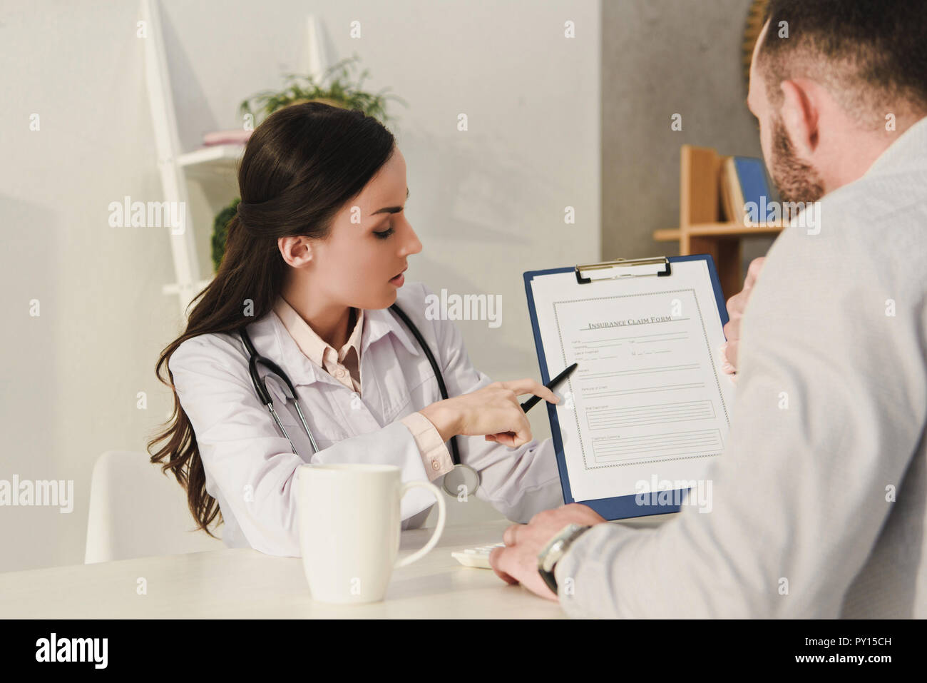 female doctor showing insurance claim form to client Stock Photo Alamy