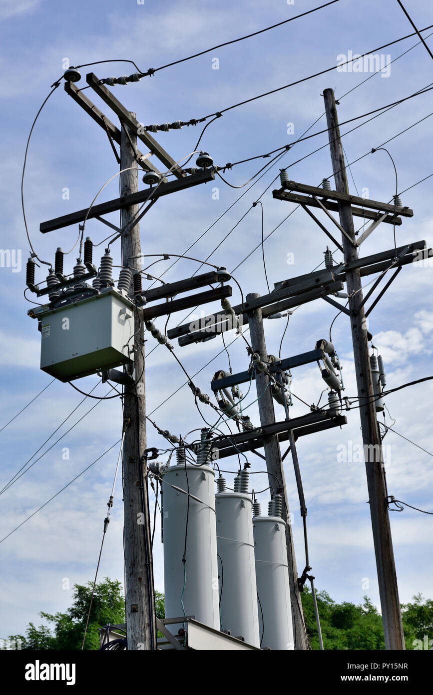 Power lines and local distribution transformers on wooden power poles, New York State, USA Stock Photo