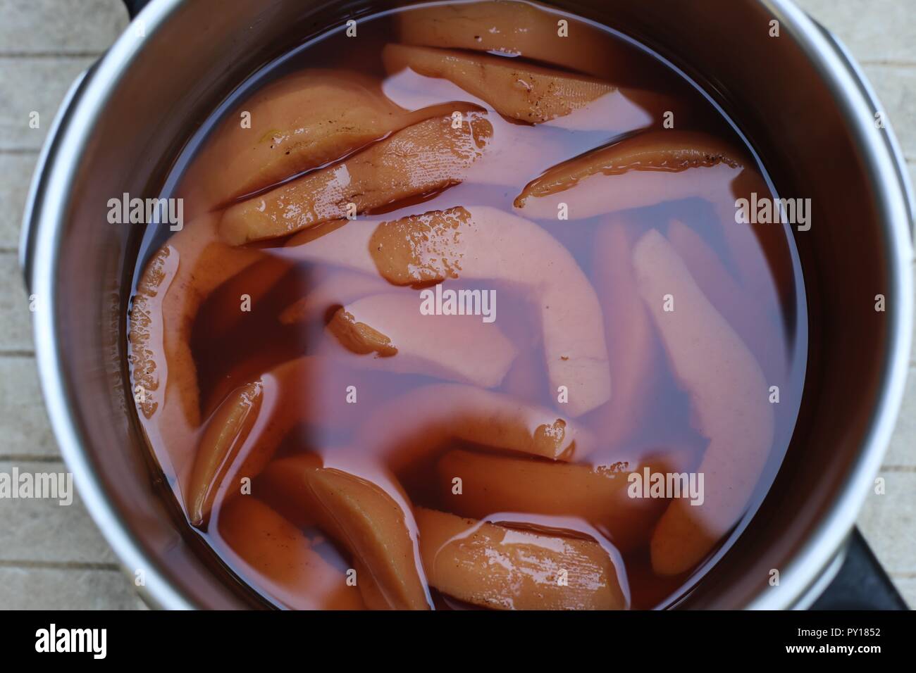 Dish With Quince Pieces. Stack of fresh peeled quince slices in a glass dish before being cooked for dessert. Stock Photo