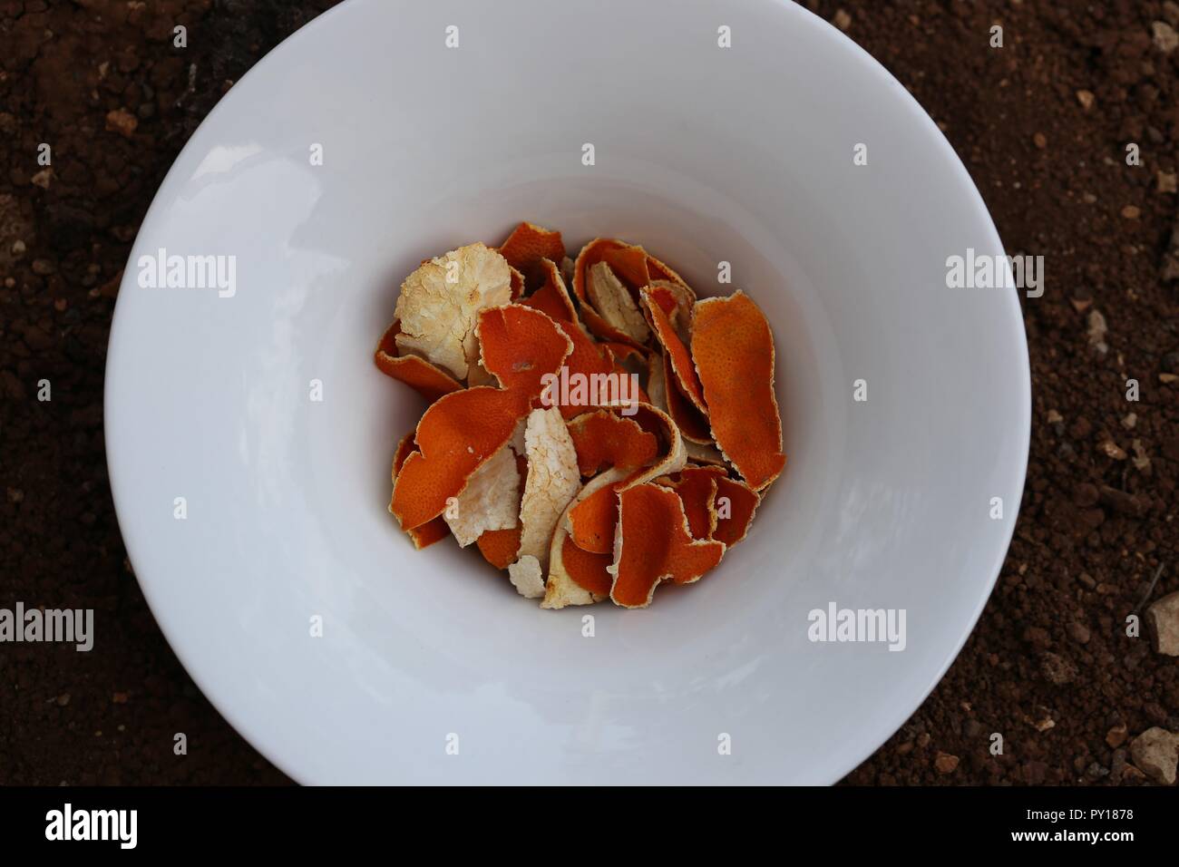 Tangerine Peels. Home Remedy. Dried clementine peels in white bowl on the ground. Homemade medicine, infusion of dried mandarin peels, herbal remedies Stock Photo