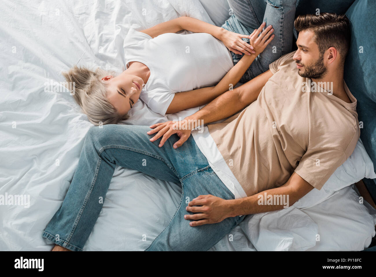 overhead view of beautiful young couple relaxing together in bedroom Stock Photo