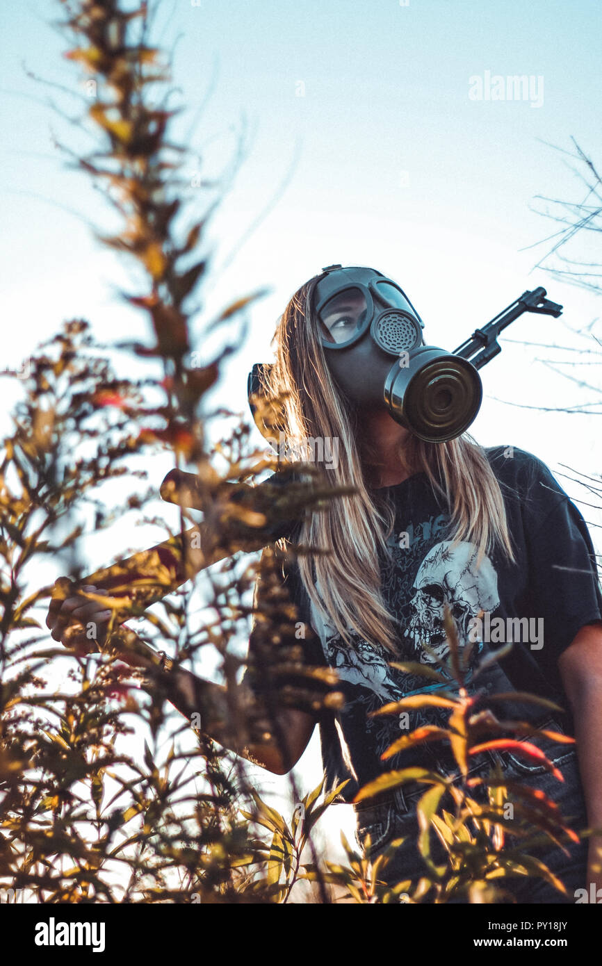 A friend of mine with an old cm4 gas mask and a softair ak47 Stock Photo