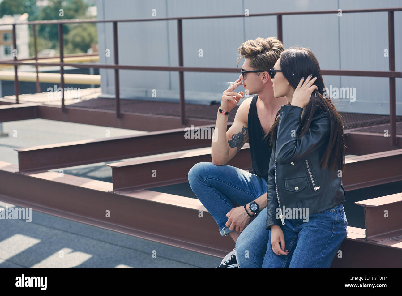 young handsome man smoking cigarette near his girlfriend Stock Photo