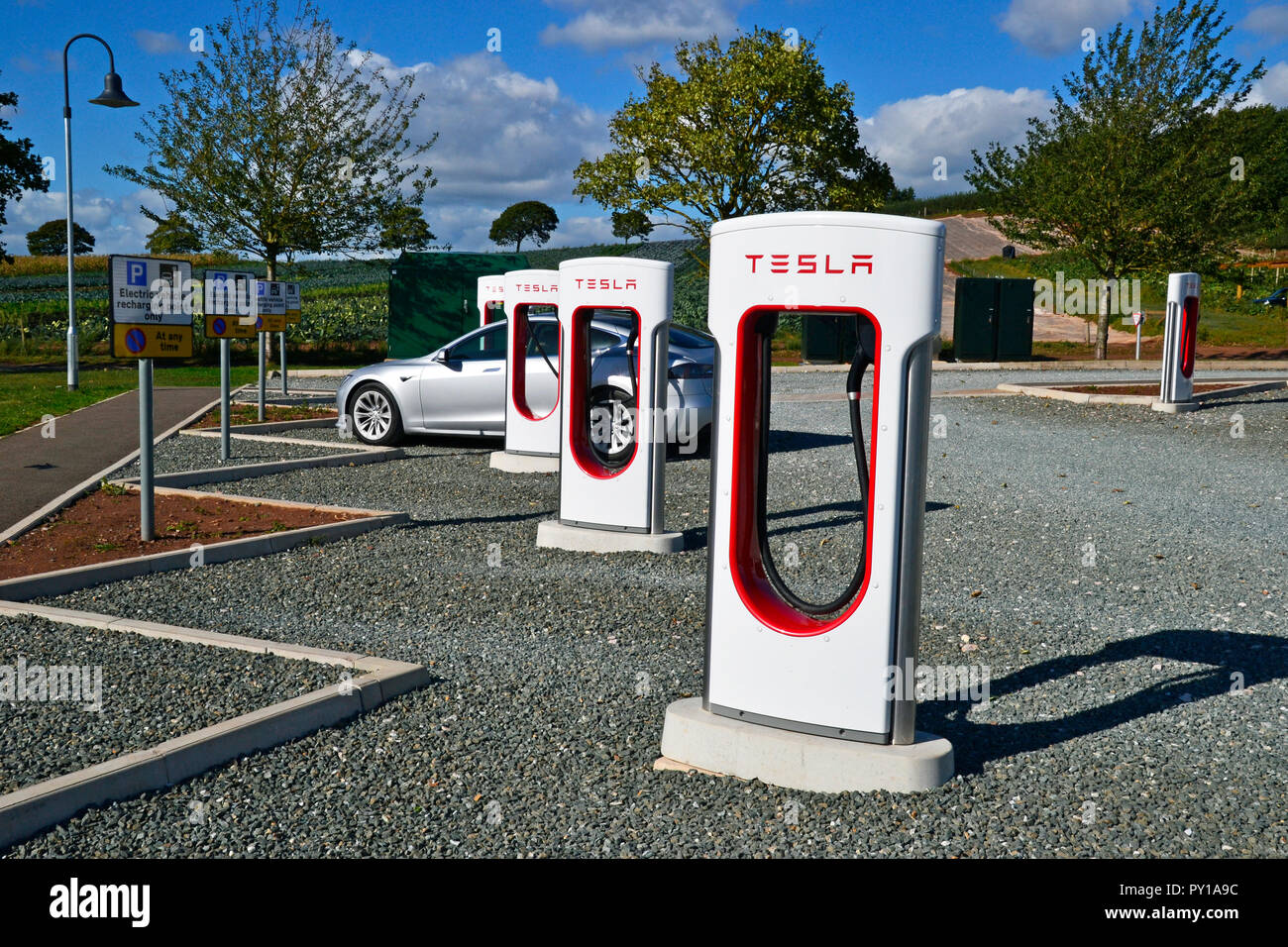 Tesla charging points for electric vehicles at Darts Farm, Exeter, Devon UK Stock Photo