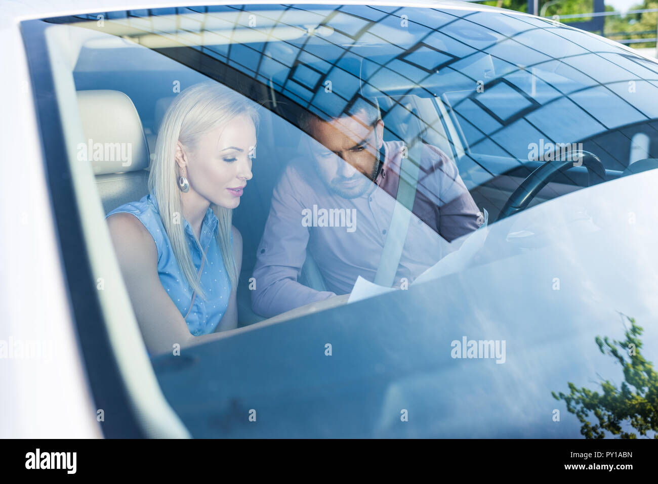 couple looking for destination on map while sitting in car Stock Photo