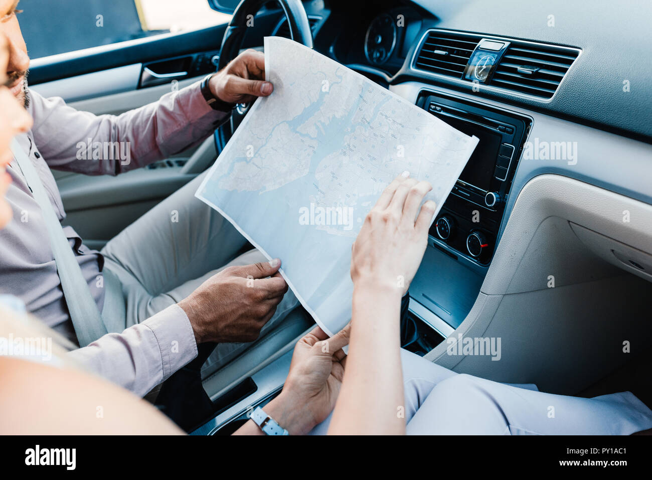 cropped shot of couple looking for destination on map while sitting in car Stock Photo