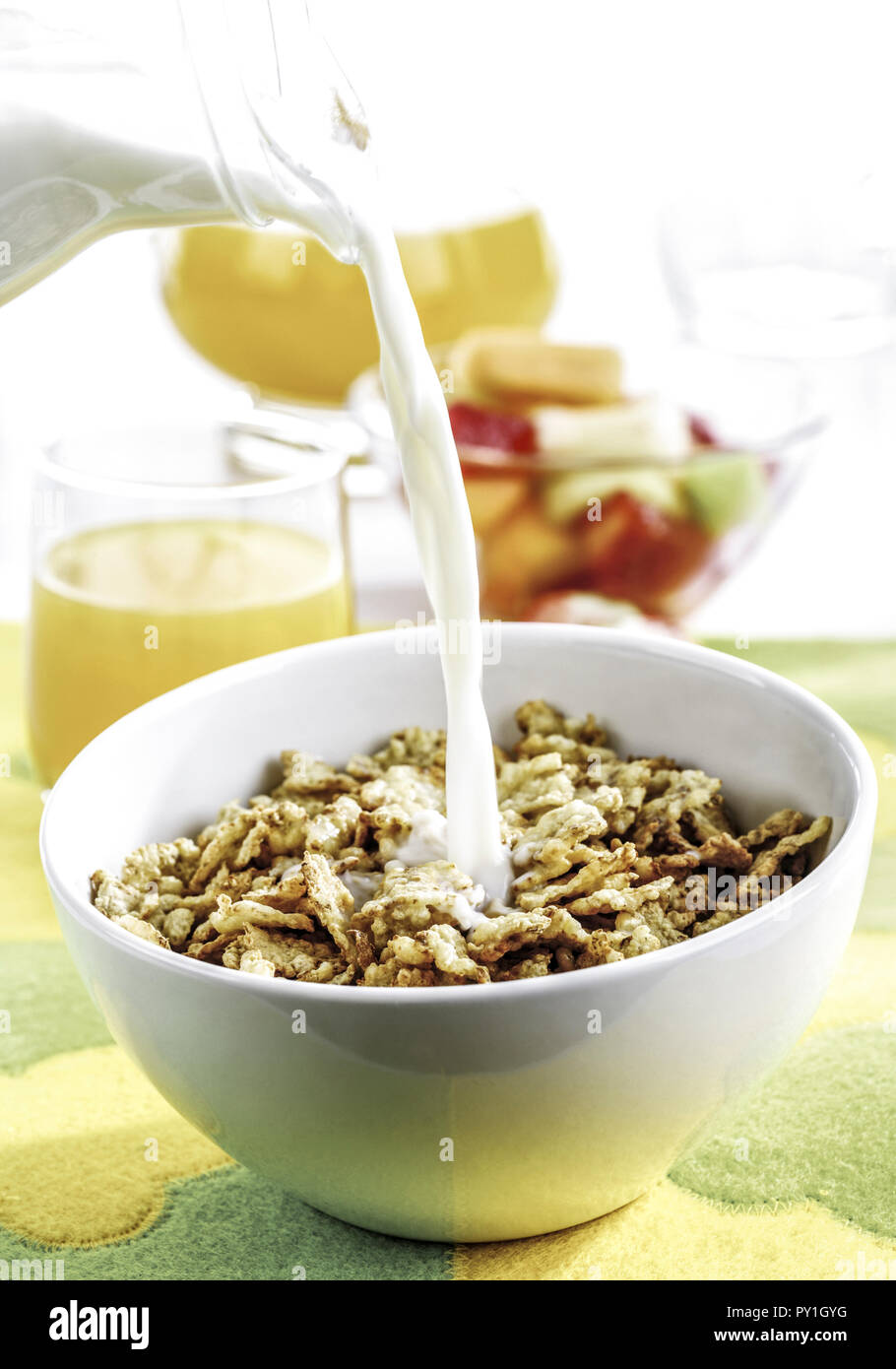 Muesli in Schuessel, Milch wird dazu gegossen Stock Photo