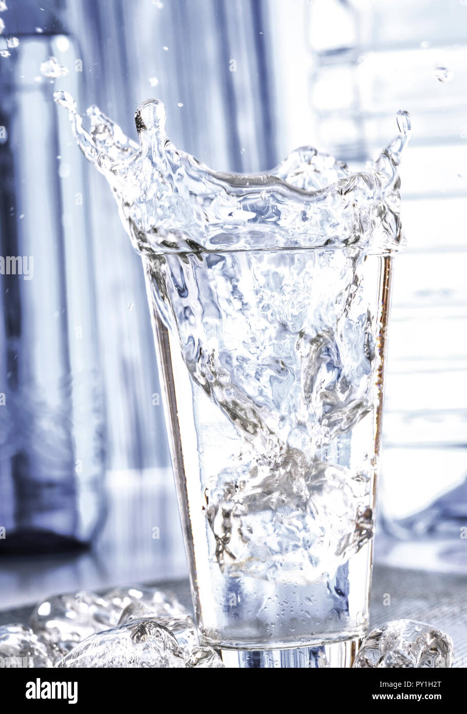 Eiswuerfel faellt in Glas Wasser Stock Photo