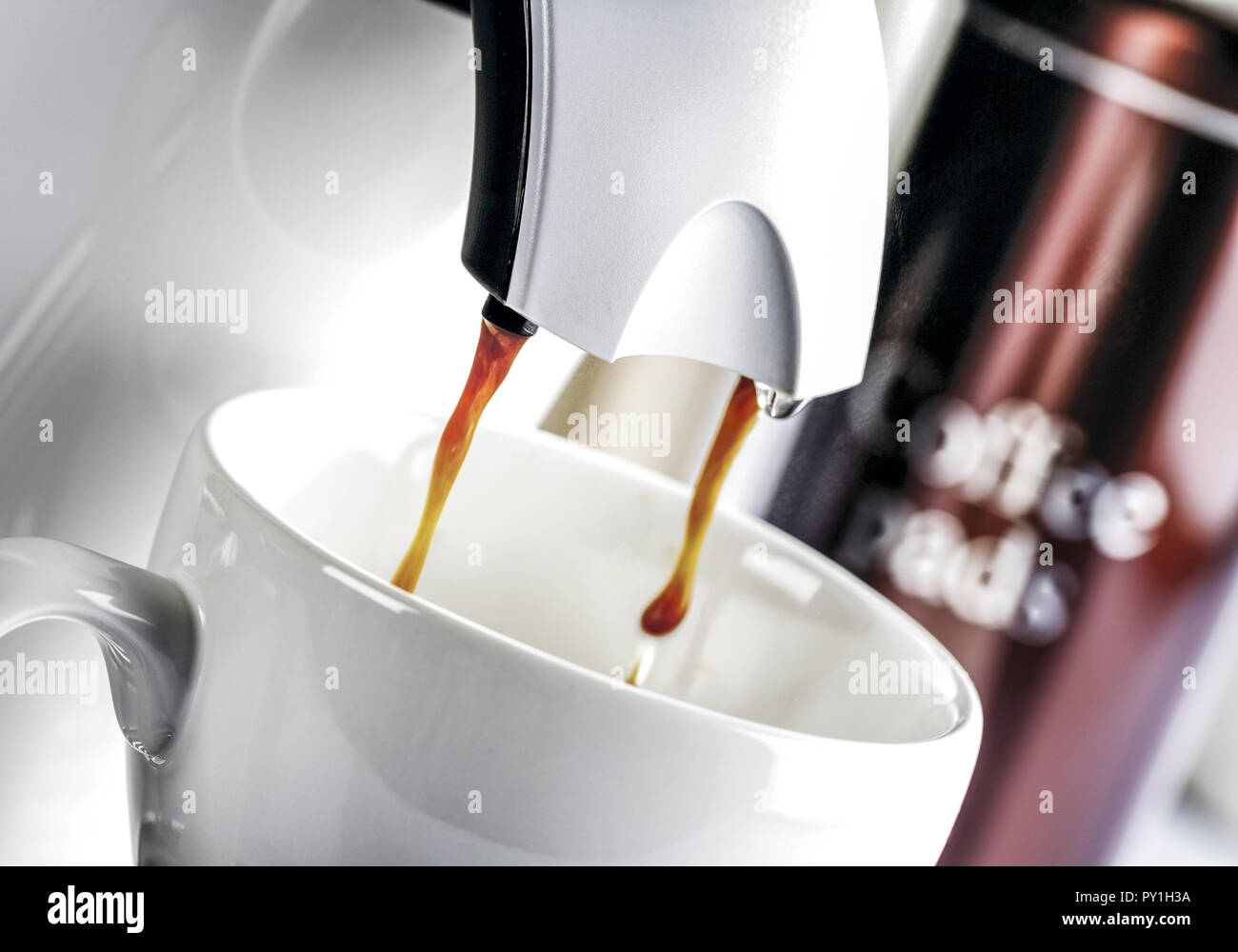 Kaffee laeuft aus Kaffeeautomat in Tasse Stock Photo