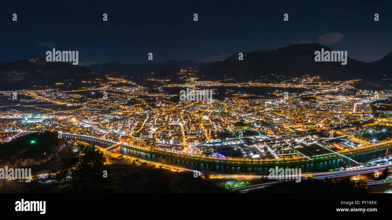 Night skyline of city in mountain valley, Trento, Italy Stock Photo