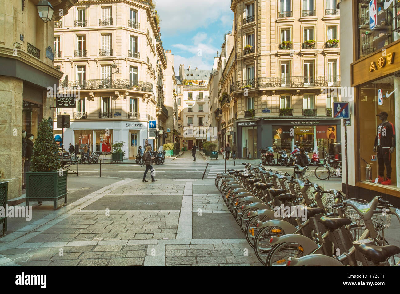 Historic street at the 4th Arrondissement in Paris with public rental bicycles, France Stock Photo