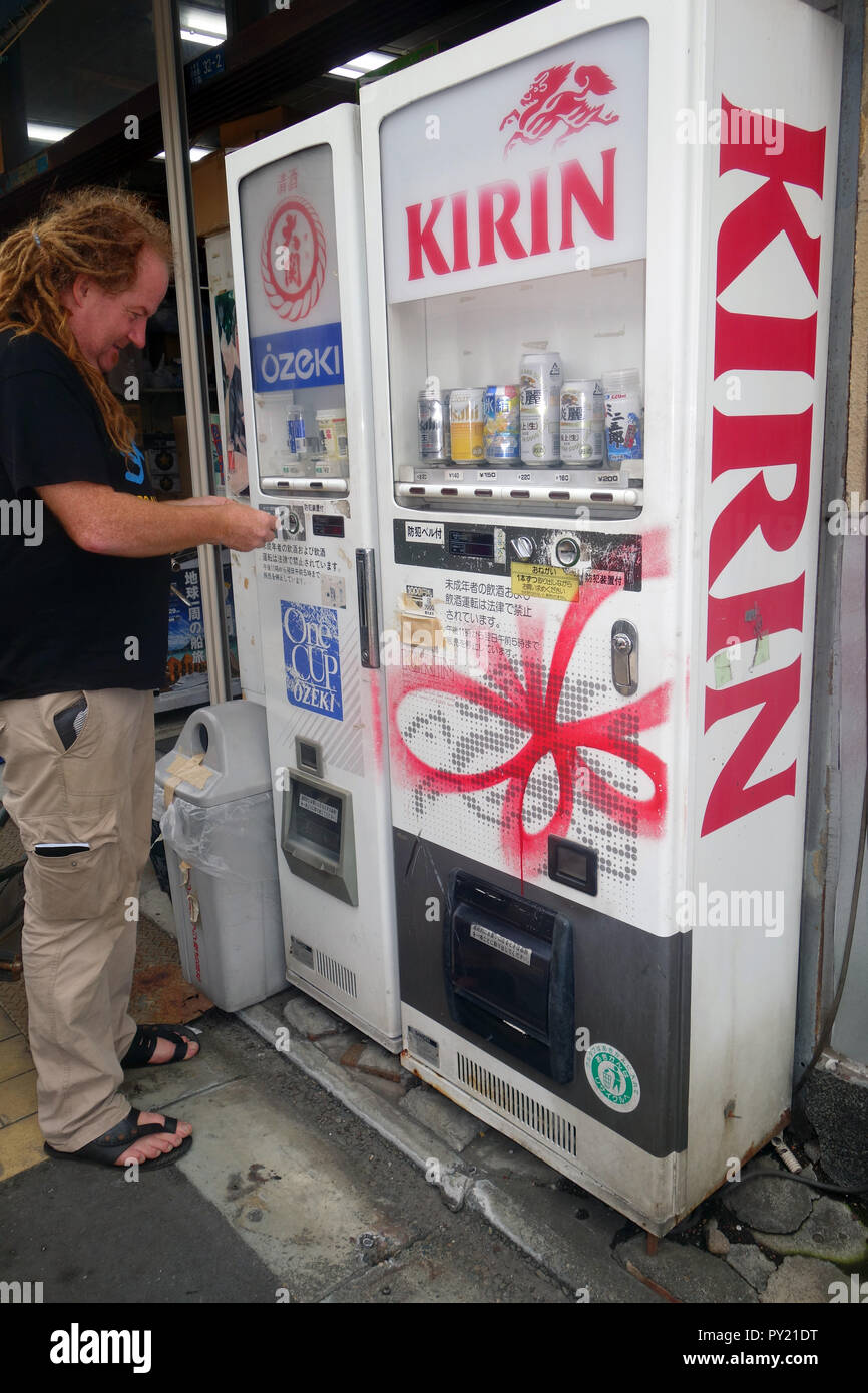 Man buying sake from vending machine on the street, Tokyo, Japan. No PR or MR Stock Photo