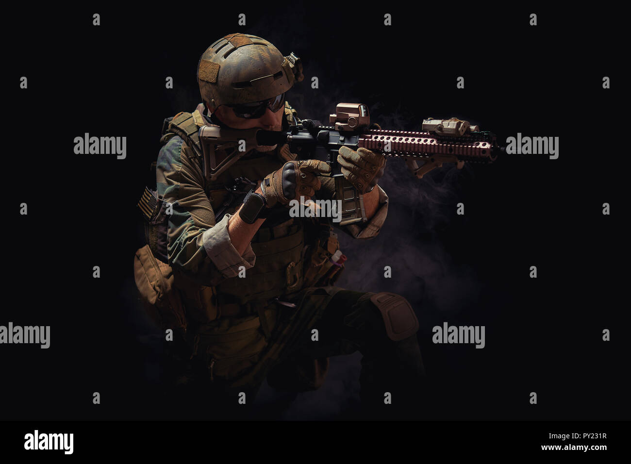 special forces soldier of the united states poses with a rifle on a black background Stock Photo