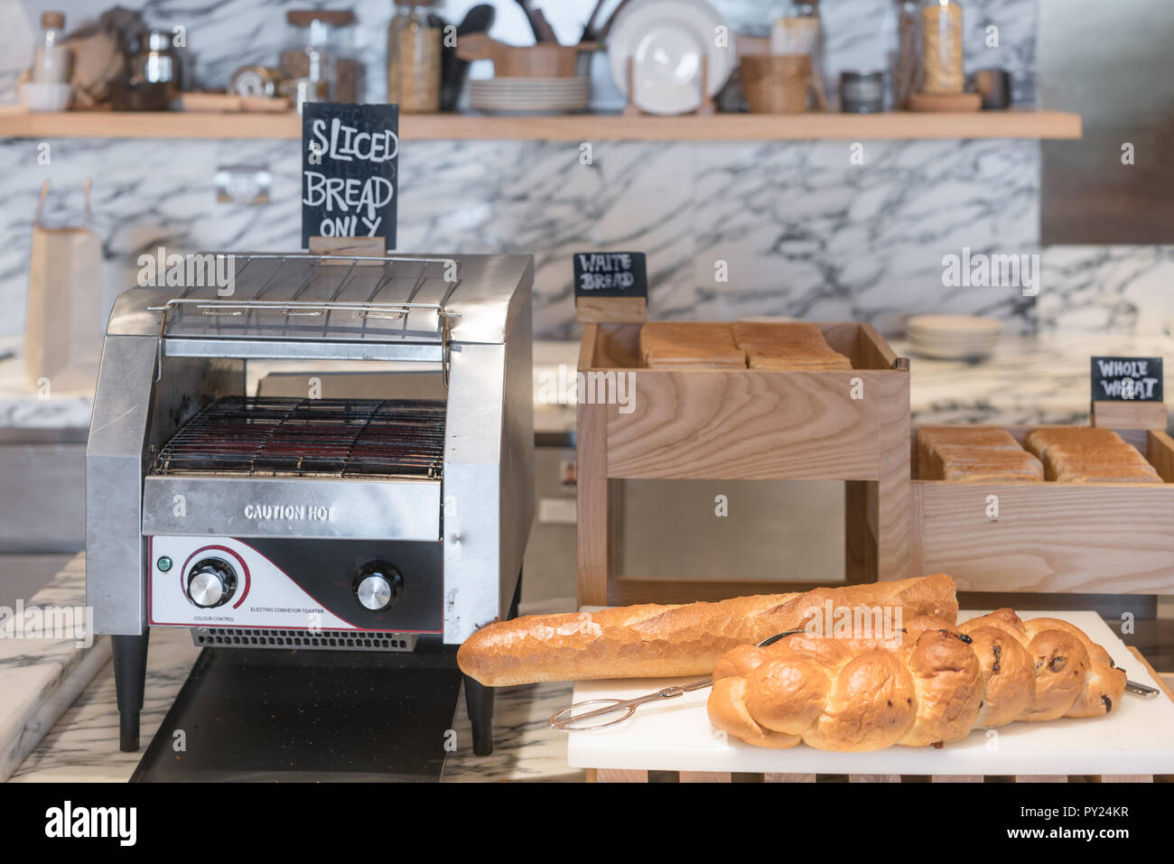 International buffet with assorted bread and toast line and toaster on table in breakfast buffet at kitchen in hotel. Stock Photo