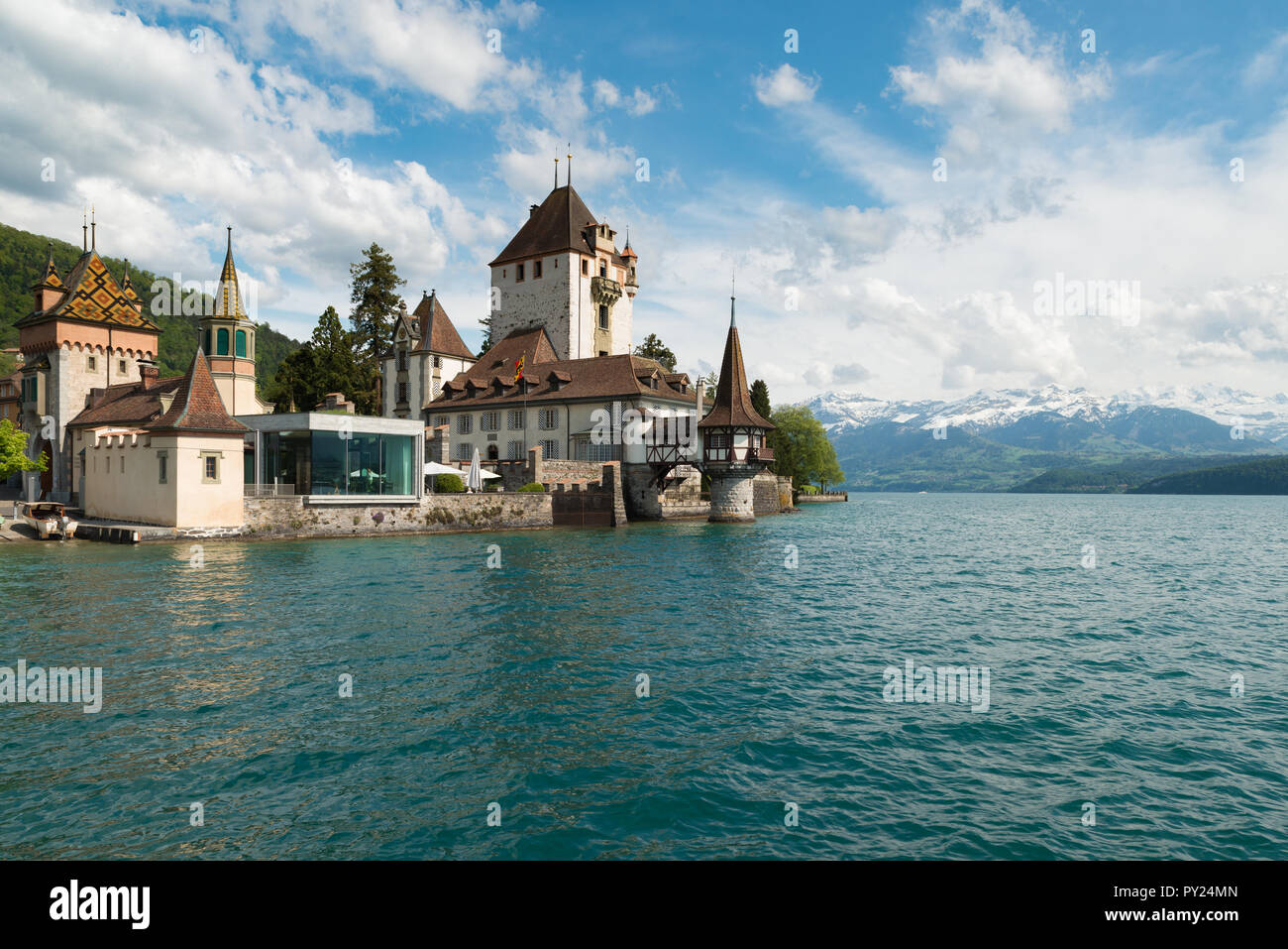 Beautiful little tower of Oberhofen castle in the Thun lake with mountains on background in Switzerland, near Bern Stock Photo