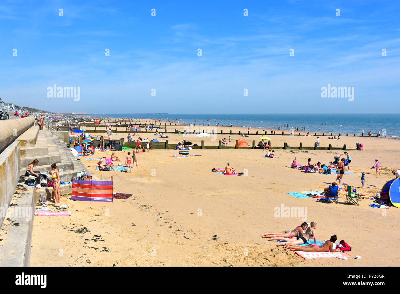 2018 hot weather summer crowds of holiday people on Essex seaside sand coast family beach for safe play & sunbathing Frinton on Sea resort England UK Stock Photo