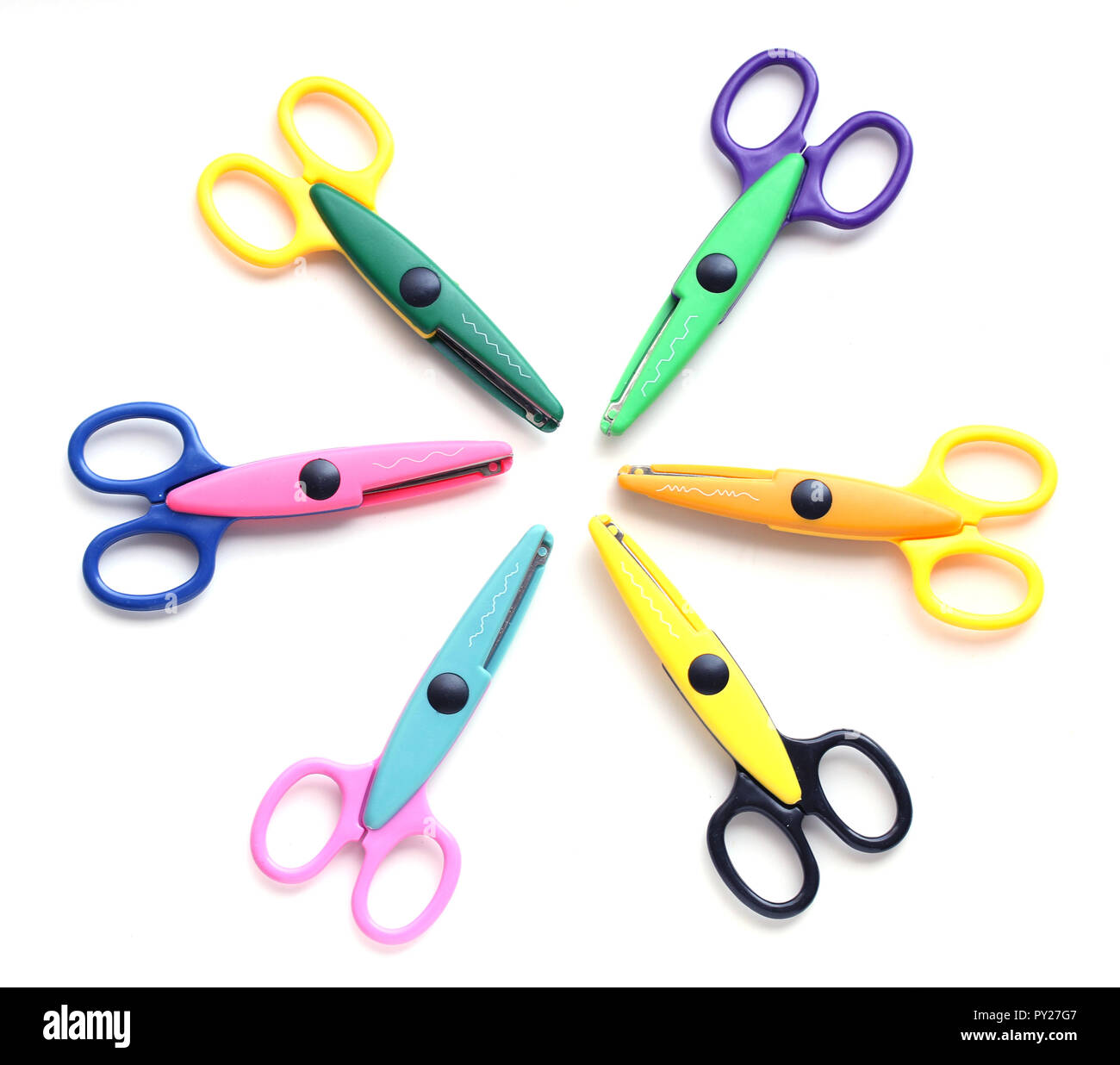 Six childrens pinking shears in a circle isolated on white Stock Photo