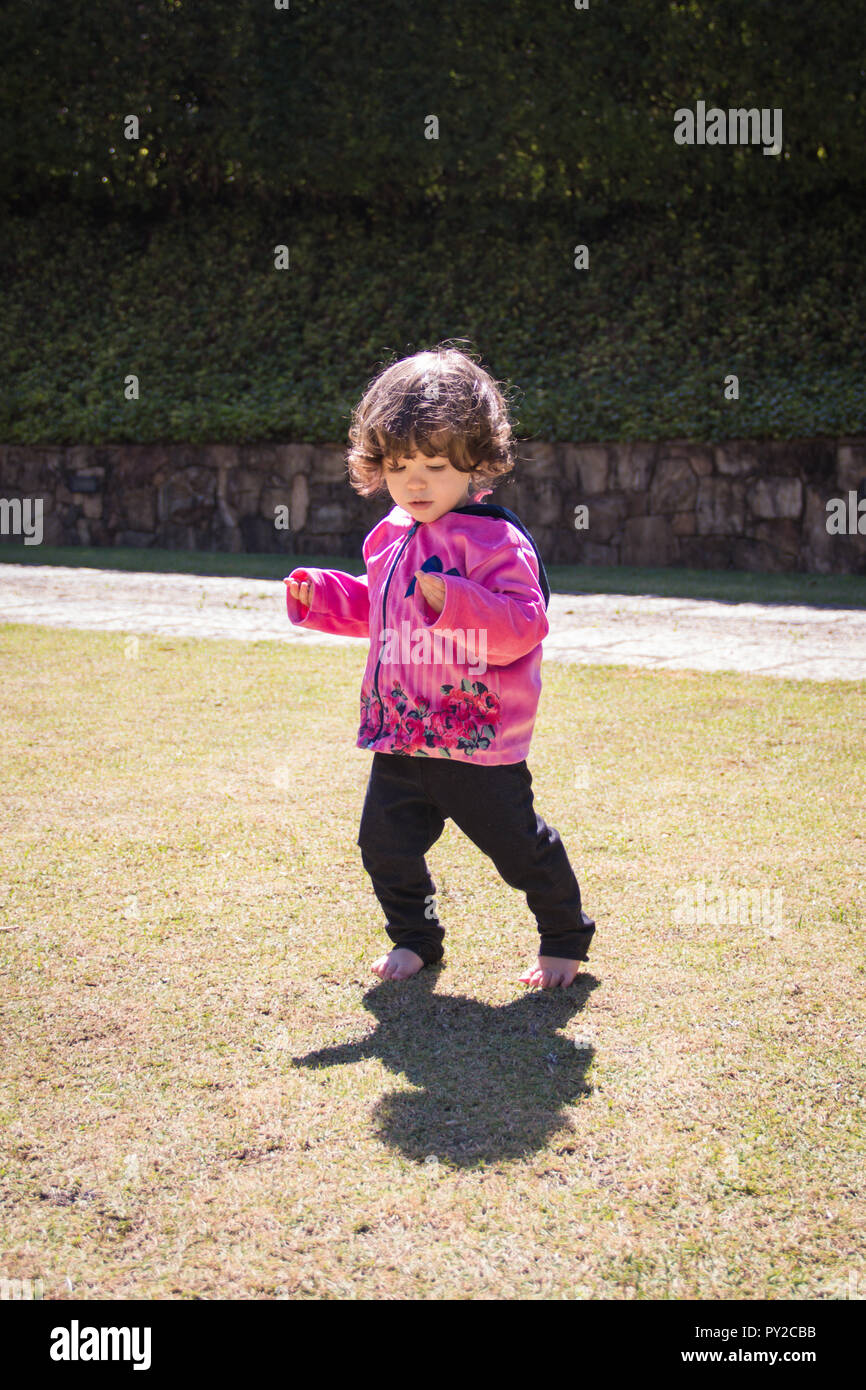 Toddler walking barefoot in the grass Stock Photo