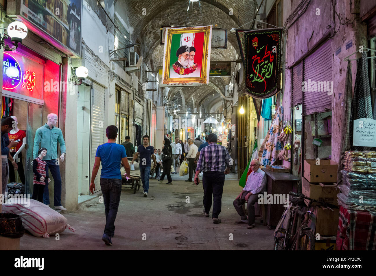 ISFAHAN, IRAN - AUGUST 20, 2018: Street of the Isfahan bazar with an Iranian flag hanging with the portraits of the 2 Supreme leaders of the Islamic R Stock Photo
