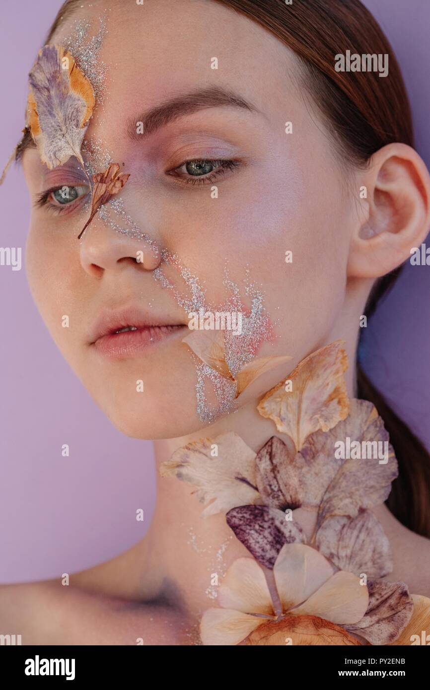 Conceptual beauty portrait of a woman with dried flowers on her face Stock Photo