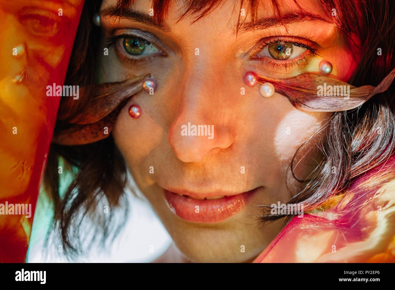 Conceptual beauty portrait of a woman with pearls and a leaf on her face Stock Photo