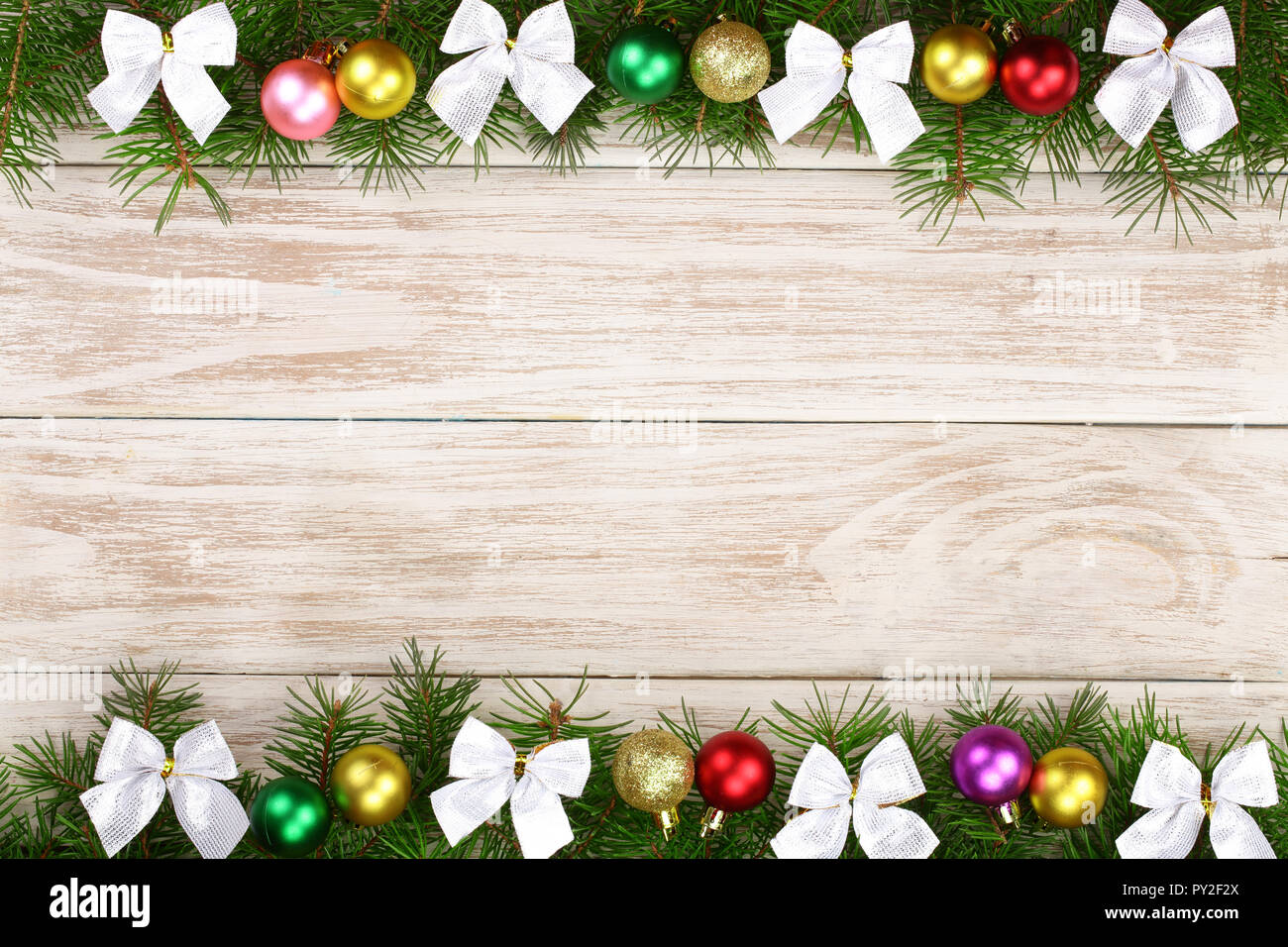 Christmas frame made of fir branches decorated with balls and bows on a ...