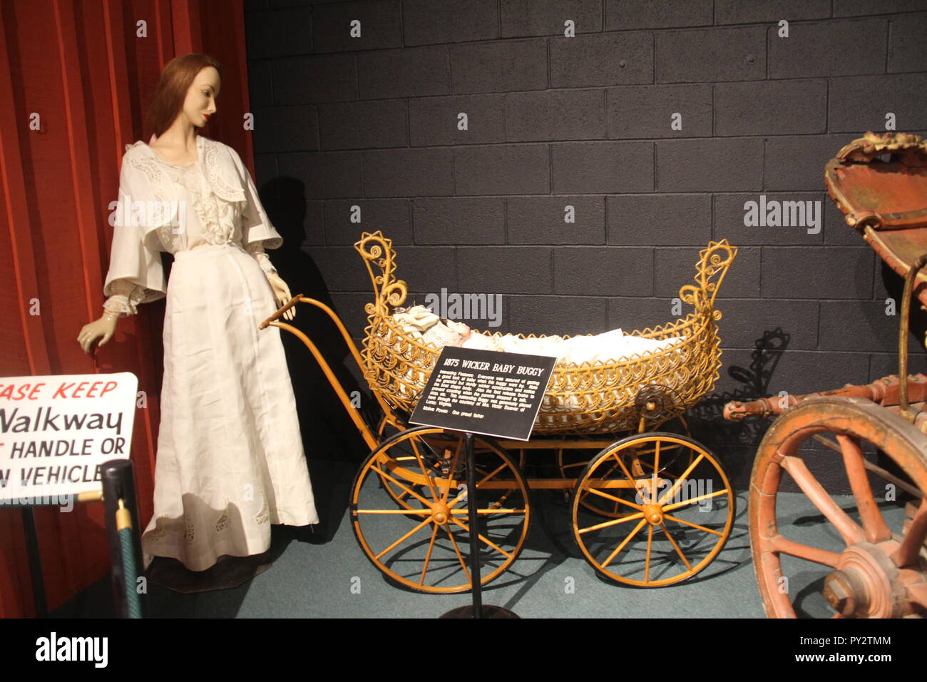 Woman with baby buggy, retro display at The Car and Carriage Caravan