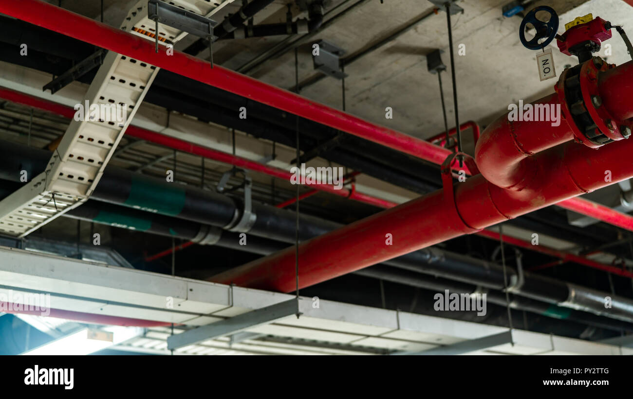 Fire sprinkler system with red pipes hanging from ceiling inside building.  Fire Suppression. Fire protection and detector. Main supply water piping in  Stock Photo - Alamy