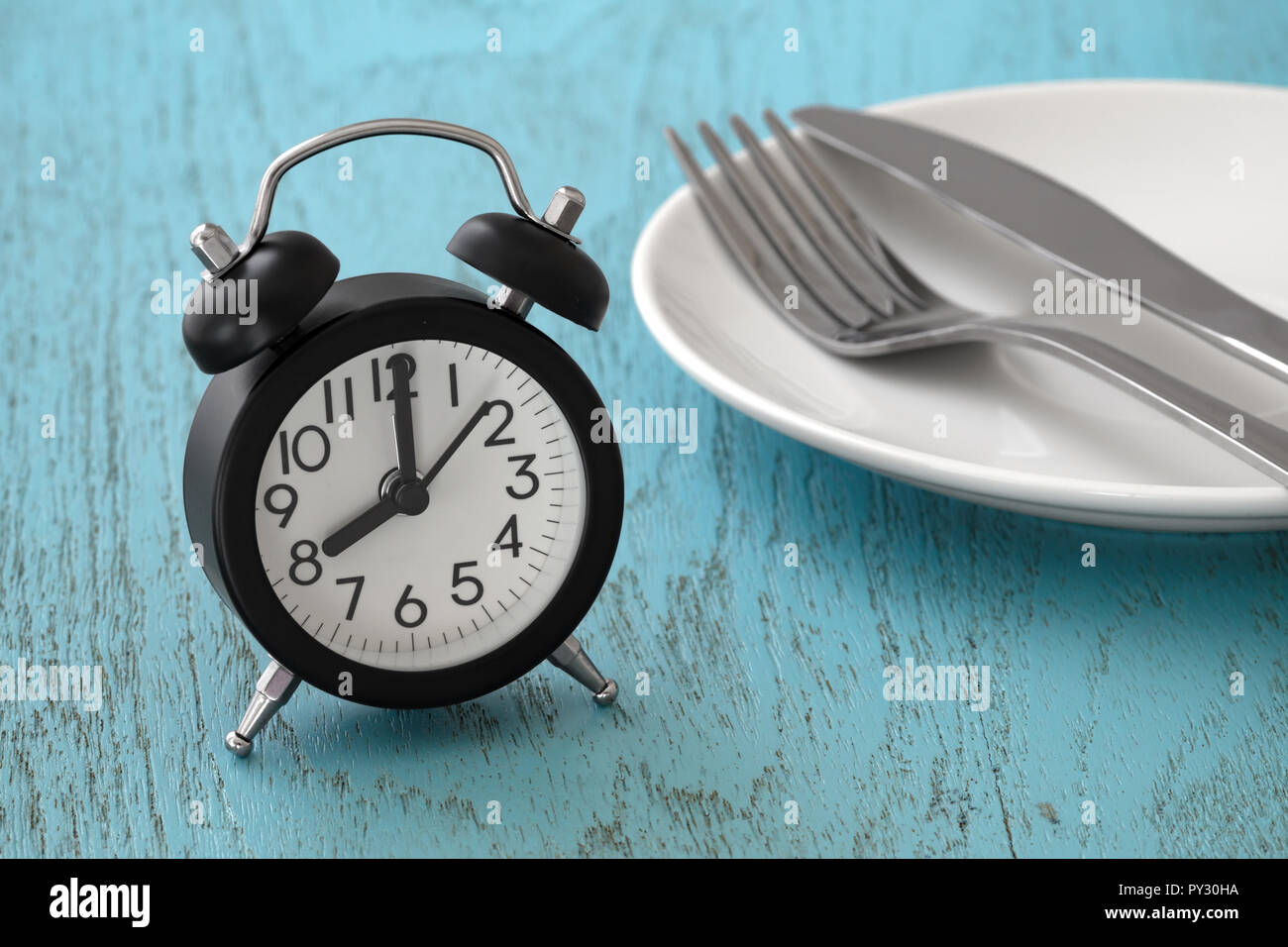 Clock with fork and knife on white plate, intermittent fasting, meal plan, weight loss concept Stock Photo