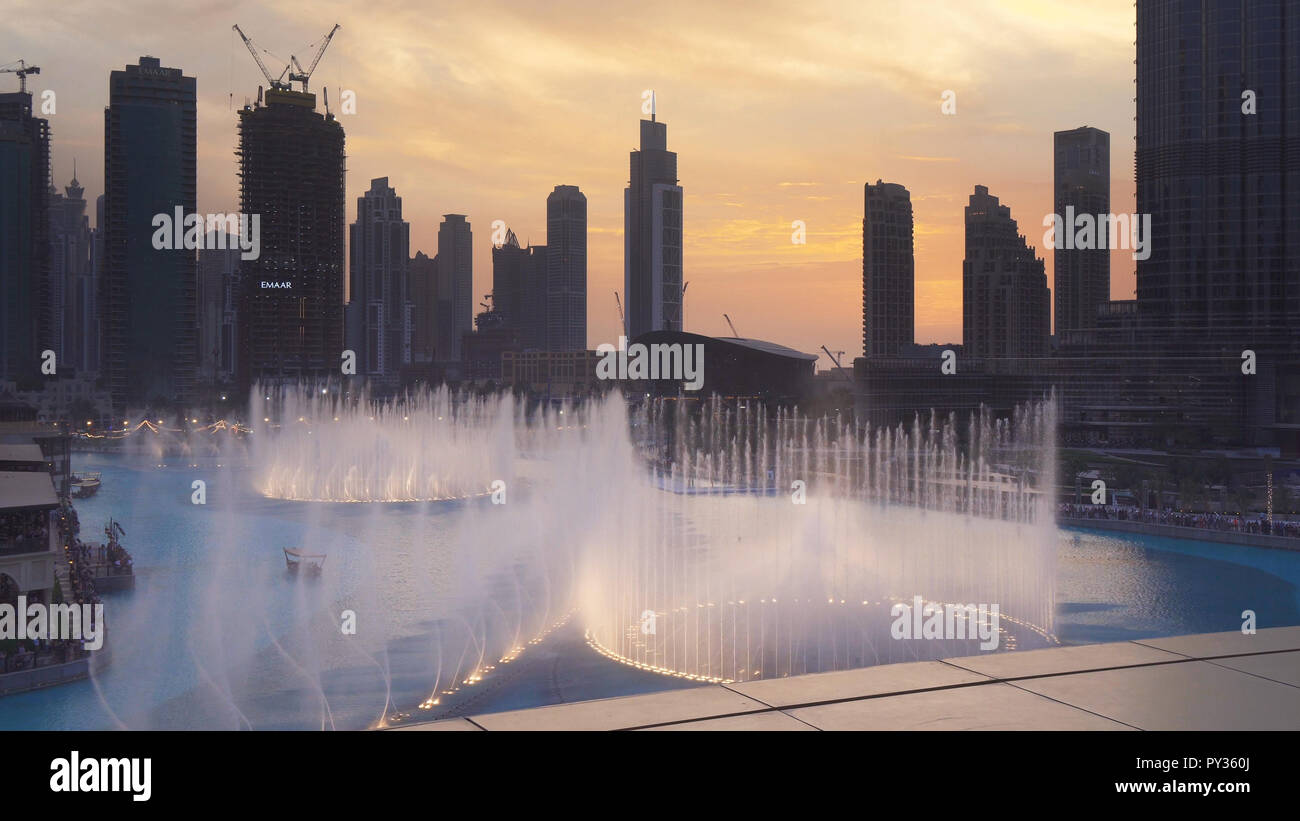 Dubai Fountain is the world's largest choreographed fountain system on sunset background Stock Photo