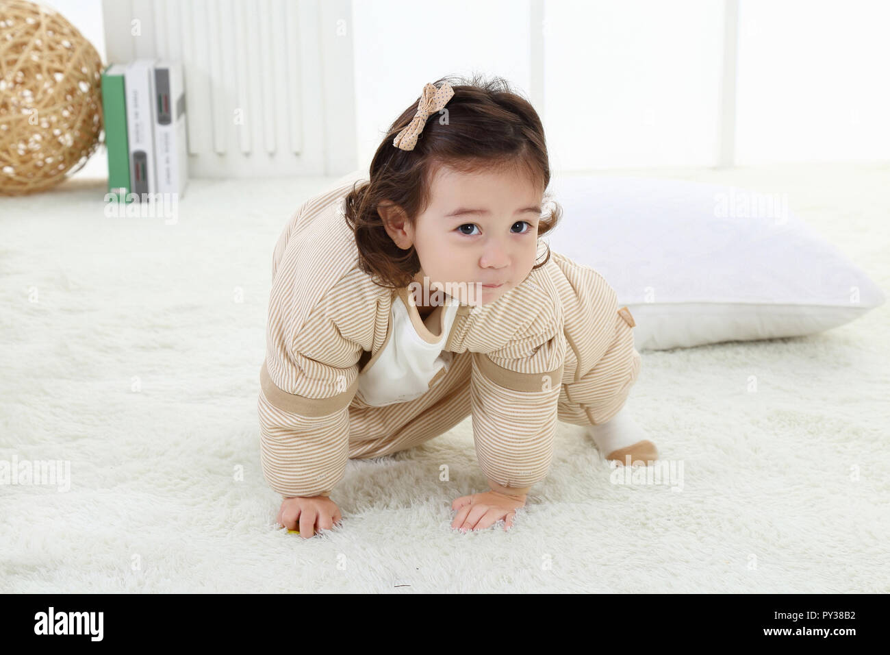 the cute little girl was playibg in the room wearing ababy Stock Photo