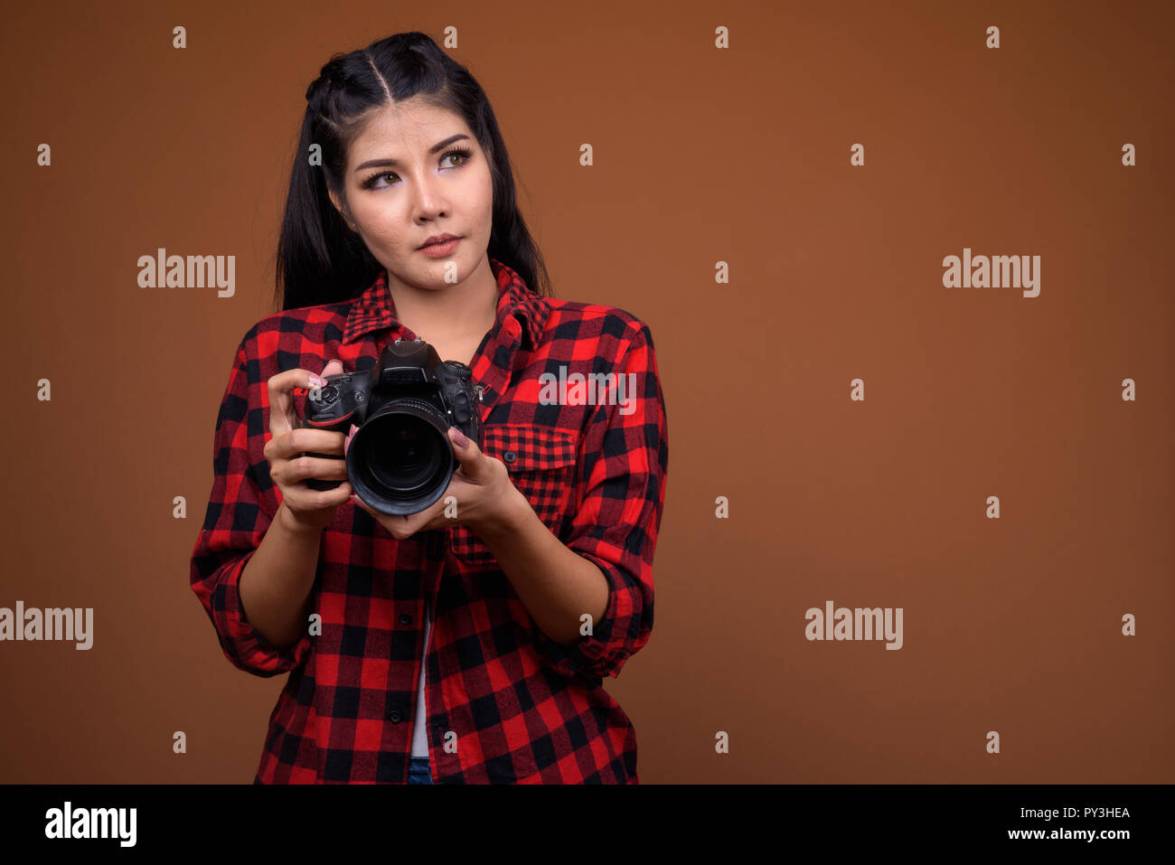 Young beautiful Asian woman photographer thinking and looking up Stock ...