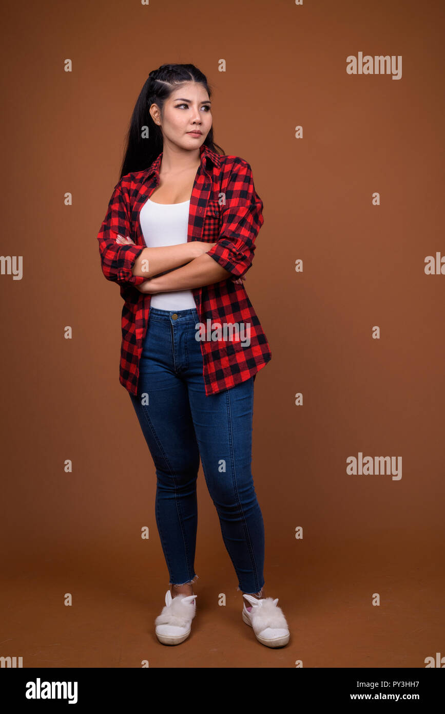 Studio portrait of young beautiful Asian woman thinking Stock Photo - Alamy