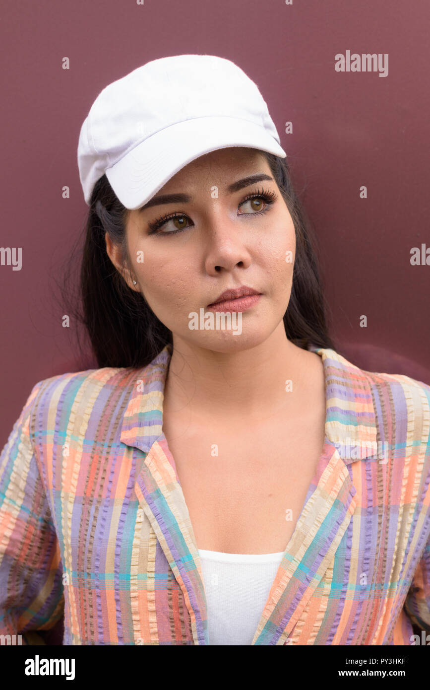 Young beautiful Asian tourist woman thinking and looking up Stock Photo
