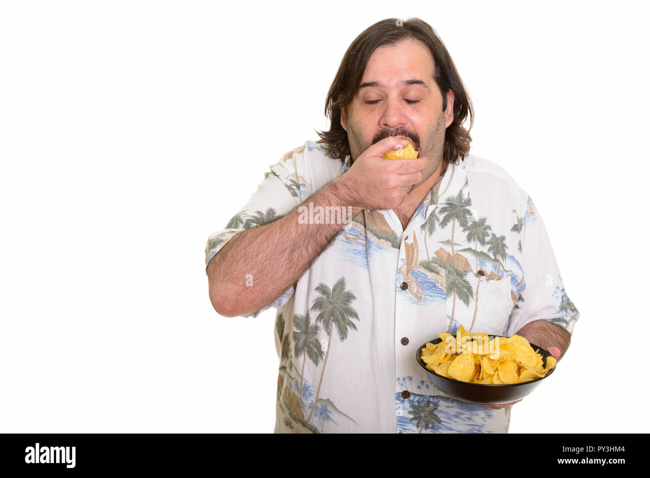 Fat Caucasian man eating deliciously mouthful of chips ready for Stock Photo
