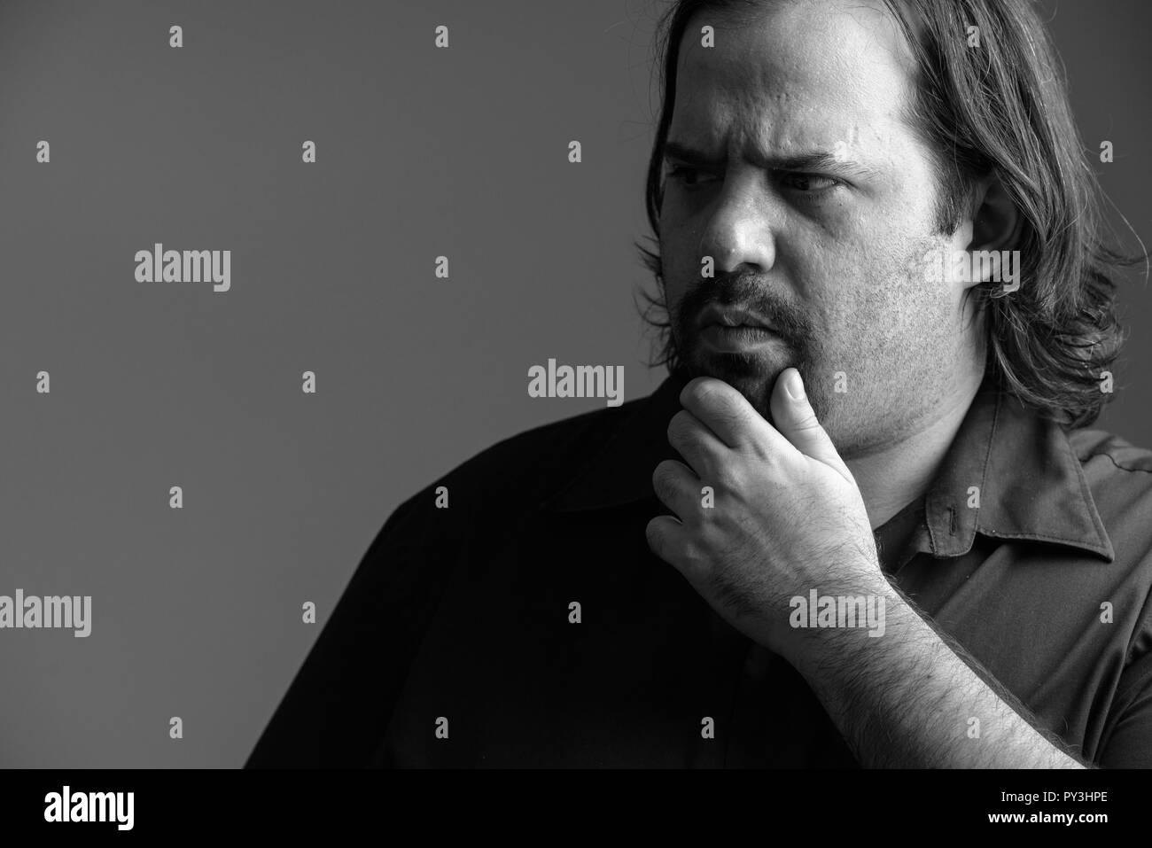 Close up of fat Caucasian man thinking in black and white Stock Photo