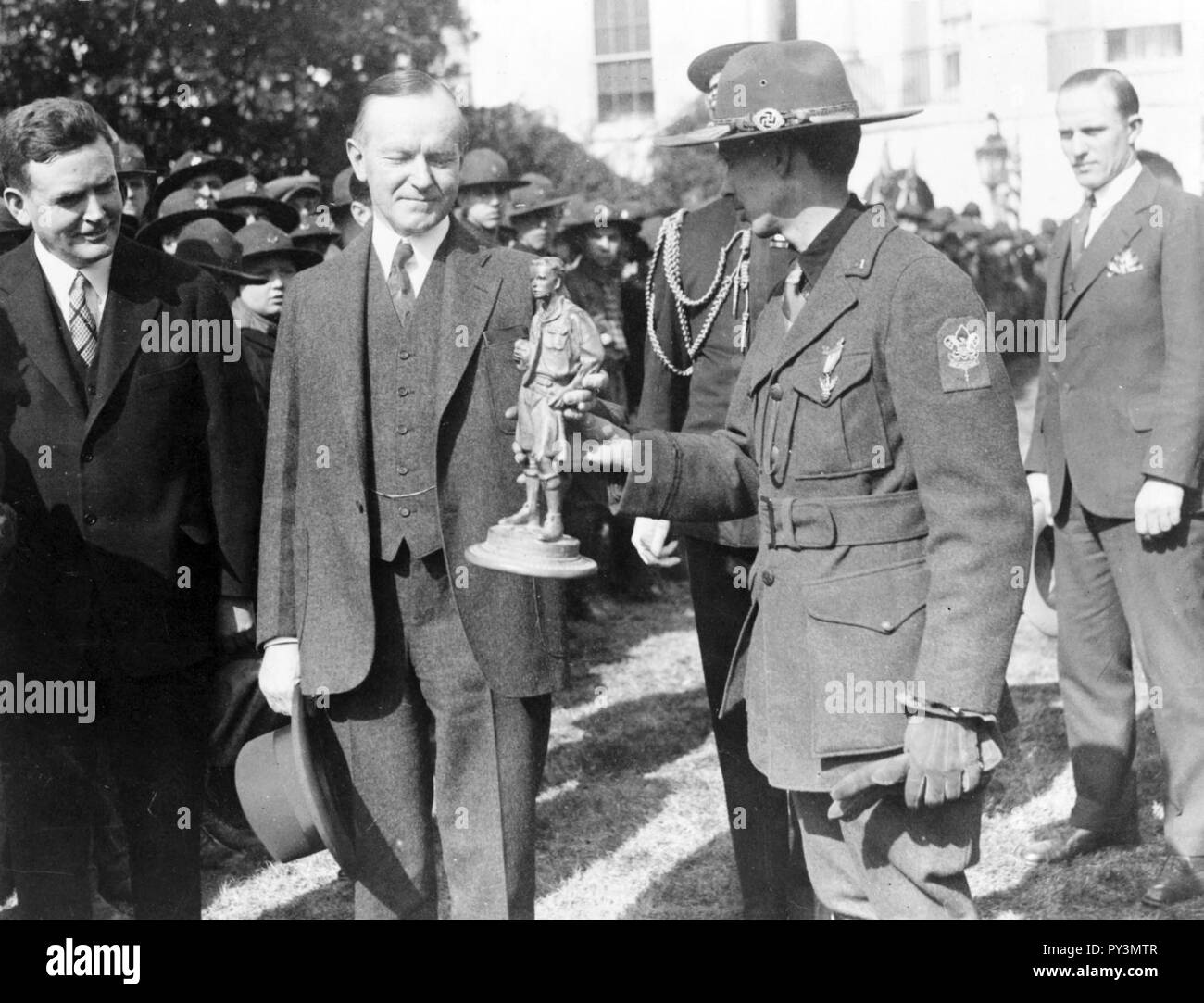 Calvin Coolidge receiving statue of Boy Scout outside the White House