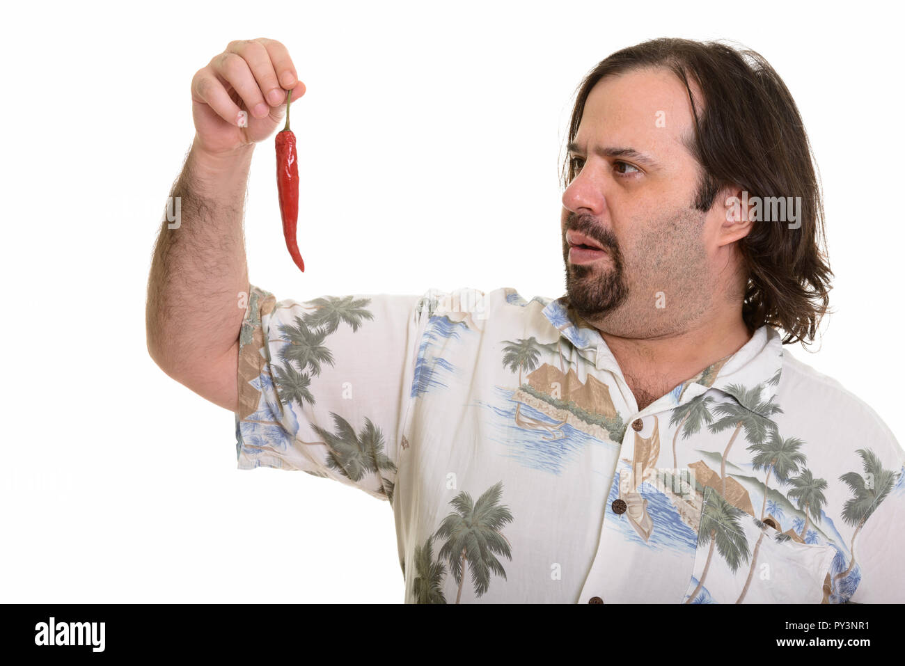 Fat Caucasian man looking at spicy chili pepper Stock Photo