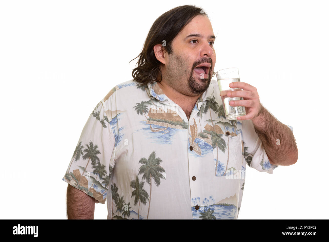 Fat Caucasian man drinking glass of water looking away Stock Photo