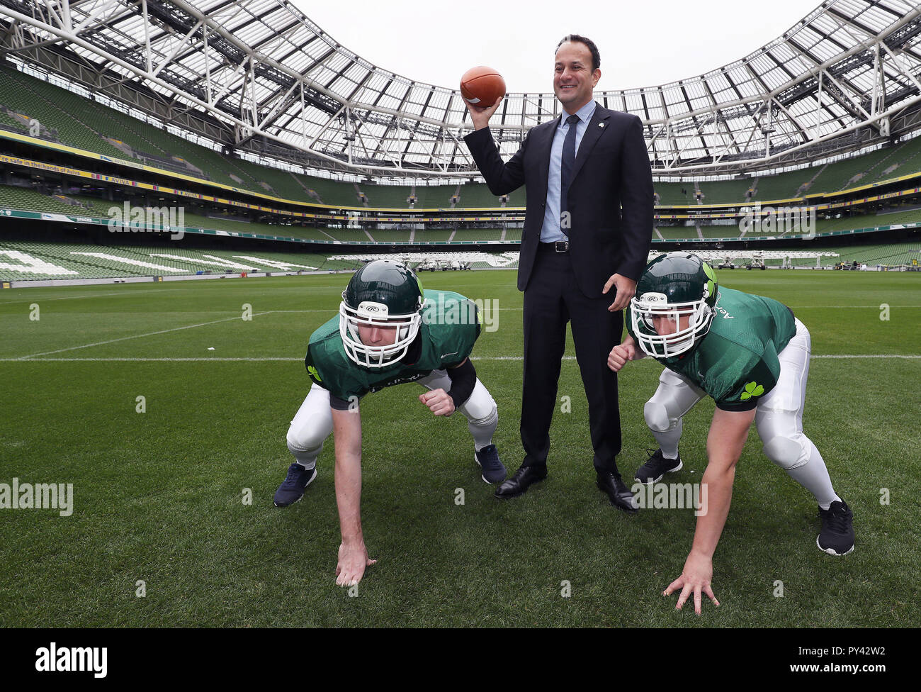 An Taoiseach Leo Varadkar with players from Cork Admirals American football team Cillian McGillycuddy (left) and Aidan Waters, at the Aviva stadium, Dublin, for the announcement of plans for a five-game American college football series. Stock Photo